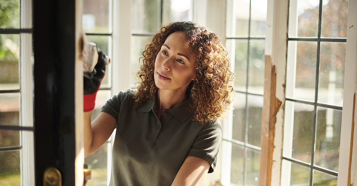 A woman painting her front door