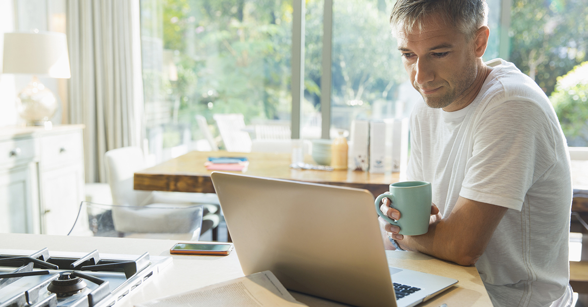 A man on his laptop in the kitchen