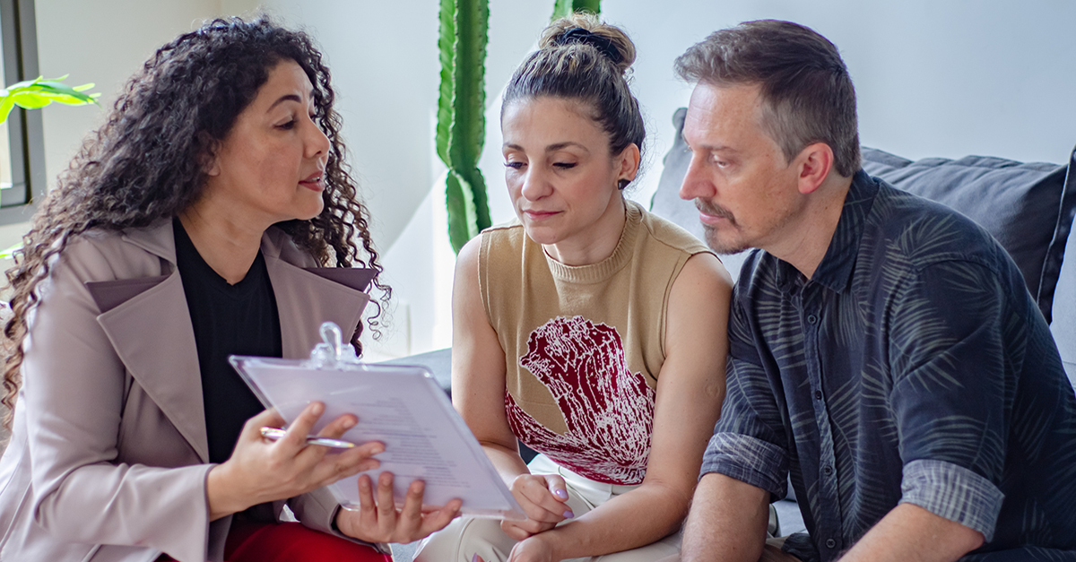 An agent reviewing documents with her clients