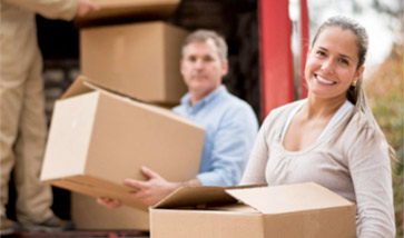 couple loading boxes onto truck